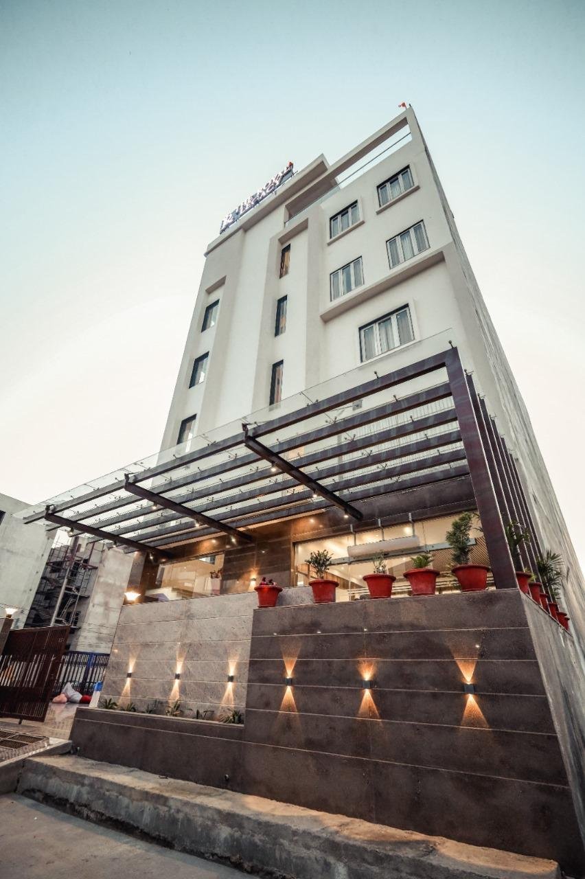 The Royal Legacy Hotel Facade at Dusk with Sconces and Glass Canopy